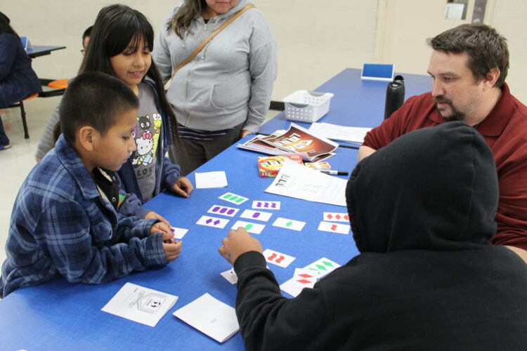 Three students play a math card game.